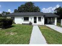Charming single-story home with a covered front entrance and well-maintained lawn at 793 N Kentucky Ave, Umatilla, FL 32784