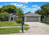 Charming single-story home features a well-maintained lawn, beautiful landscaping, and a two-car garage at 1631 Woodbay Ct, Kissimmee, FL 34744