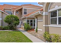 Charming two-story home with a well-maintained lawn, tile roof, and inviting walkway to the front door at 1760 Saint Tropez Ct, Kissimmee, FL 34744