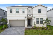 Charming two-story home featuring a two-car garage, well-maintained lawn, and welcoming front entrance at 2176 Lelani Cir, Davenport, FL 33897