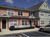Multi-story townhome featuring an attractive color scheme, front porch, and well-maintained landscaping at 2219 San Vittorino Cir # 106, Kissimmee, FL 34741