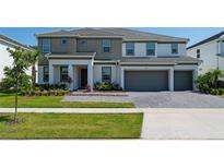 Charming two-story home featuring a two-car garage, a landscaped front yard, and an elegant entryway at 2397 Shanti Dr, Kissimmee, FL 34746