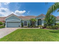 Charming single-story home with lush lawn and tile roof, showcasing a well-manicured front yard and inviting facade at 2540 Swoop Cir, Kissimmee, FL 34741