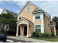 Two-story home with peach siding, white trim, and a black front door at 3301 Soho St # 104, Orlando, FL 32835