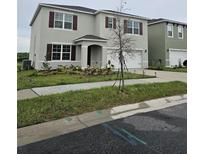 Two story home with a two car garage, manicured lawn, and a well maintained landscape at 3886 Whitney Way, Haines City, FL 33844