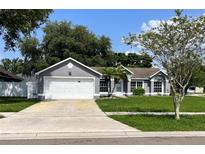 Charming single-story home featuring a well-manicured lawn and attached two car garage at 4215 Red Bird Ave, St Cloud, FL 34772