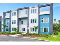 Modern three-story townhome featuring colorful facades and manicured landscaping for enhanced curb appeal at 7770 Sandy Ridge Dr # 142, Kissimmee, FL 34747