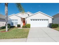 Well-maintained single-Gathering home with a two-car garage and manicured lawn at 8121 Fan Palm Way, Kissimmee, FL 34747
