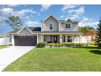 Charming two-story home with a well-manicured lawn and a welcoming front porch at 108 Honeywood Ct, Kissimmee, FL 34743