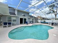 Inviting screened-in pool features multiple seating areas and convenient access to the home's interior at 108 Honeywood Ct, Kissimmee, FL 34743