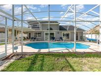 Screened-in pool with sunbathing chairs, outdoor furniture, and a lovely view of the home at 108 Honeywood Ct, Kissimmee, FL 34743