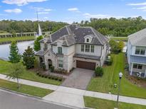 Stunning two-story home featuring stone accents, a paver driveway, and a well-manicured lawn in a desirable neighborhood at 10950 Belle Maisons Dr, Orlando, FL 32832
