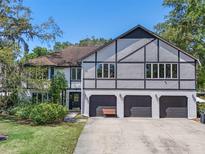 Charming multi-story home boasting a three-car garage, manicured lawn, and architectural details at 11951 Elbert St, Clermont, FL 34711