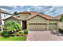 Beautiful single-story home featuring a tile roof, two-car garage, and neatly landscaped front yard at 1353 Palmetto Dunes St, Davenport, FL 33836