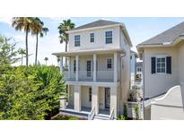 Charming two-story home with a double balcony, stucco siding, and a beautiful landscaped yard at 1379 Kiawah St, Celebration, FL 34747