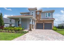 Stunning two-story home with a brick driveway, a covered porch, and a two-car garage at 15600 Vetta Dr, Bella Collina, FL 34756