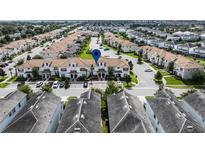 Community aerial view showcasing the well-maintained townhomes with tiled roofs and lush landscaping at 1578 Slice Way, Davenport, FL 33896