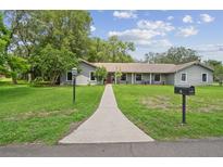 Charming single story home with a well manicured lawn and inviting walkway to the front door at 16 Pine Forest Dr, Haines City, FL 33844