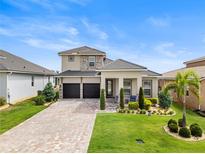 Beautiful two-story home featuring a manicured lawn and a spacious two-car garage at 16049 Volterra Pt, Bella Collina, FL 34756