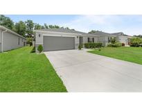Charming single-story home features a well-manicured lawn and two-car garage at 2461 Bulrush Dr, St Cloud, FL 34769