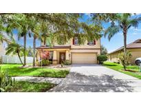 Charming home featuring mature trees, a two-car garage, and a well-maintained lawn at 2722 Corybrooke Ln, Kissimmee, FL 34744