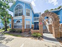 Charming blue townhouse with brick accents, arched entryway, and well-maintained landscaping at 2735 N Poinciana Blvd # 95, Kissimmee, FL 34746