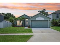 Charming single-story home with a well-manicured lawn and tropical palm trees against an orange sunset sky at 3038 Elbib, St Cloud, FL 34769