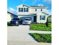 Inviting two-story home featuring a manicured lawn and neutral-toned exterior at 312 Lake Smart Cir, Winter Haven, FL 33881