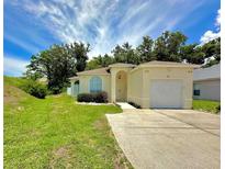 Charming single-Gathering home with manicured lawn, mature trees, and an attached one car garage at 453 Alston Dr, Orlando, FL 32835