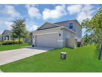 Two-story home with well-maintained lawn, paved driveway, and attached two car garage at 5225 Tuscany Ln, Davenport, FL 33897