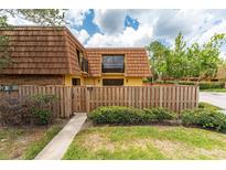 Charming townhome featuring a fenced yard, balcony, and well-maintained landscaping and beautiful blue sky at 5251 Brook Ct # 242, Orlando, FL 32811