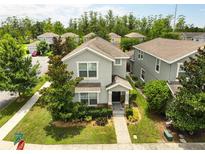 Charming two-story home featuring a well-manicured lawn and beautiful, mature trees in a residential neighborhood at 6834 Habitat Dr, Harmony, FL 34773