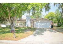 Charming single-story home with a lush, tree-filled yard and a classic two-car garage at 7410 Orange Crest Cir, Lakeland, FL 33810