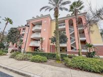 Elegant three-story building features private balconies, lush landscaping, and inviting curb appeal at 7650 Whisper Way # 102, Reunion, FL 34747