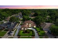 Beautiful two-story home featuring a meticulously landscaped front yard and circular driveway at 7846 Snowberry Cir, Orlando, FL 32819