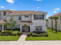 Charming two-story home with lush landscaping and a welcoming front porch at 8947 Stinger Dr, Davenport, FL 33896