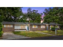 Charming single story home with a well manicured lawn and mature landscaping around the property at 1800 Banyan St, Orange City, FL 32763