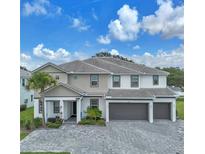Stunning two-story home boasts a three-car garage, a well-manicured lawn, and elegant architectural details at 2417 Shanti Dr, Kissimmee, FL 34746