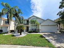 Charming two-story home with a well-manicured lawn, palm trees, and a spacious three-car garage at 2735 Scarborough Dr, Kissimmee, FL 34744