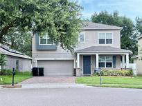 Charming two-story home boasts a two-car garage, covered porch, and well-maintained landscaping at 2813 Roseglen Way, Orlando, FL 32812