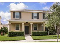 Charming two-story home with a cozy front porch, complemented by manicured landscaping and a welcoming entrance at 2966 Aqua Virgo Loop # 16, Orlando, FL 32837