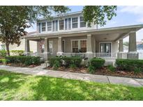 Charming two-story home with a wide porch, columns, well-manicured landscaping, and sidewalk appeal at 3310 Cat Brier Trl, Harmony, FL 34773
