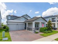 Beautiful two-story home with a two-car garage, brick driveway, covered porch, and well-manicured lawn at 5133 Citrus Leaf Blvd, Winter Garden, FL 34787