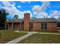 Charming brick home with a well-maintained lawn, blue skies and a prominent brick chimney at 600 Lake Butler Ave, Osteen, FL 32764