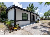 Charming single-story home with black trim, manicured landscaping, and a brick paver walkway at 722 Carlson Dr, Orlando, FL 32804