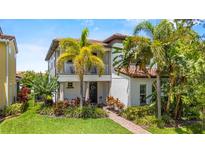 Charming two-story home featuring a cozy balcony and lush, tropical landscaping at 10067 Mere Pkwy, Orlando, FL 32832