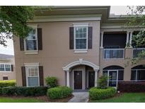 Charming townhome showcasing a private balcony and beautifully landscaped front entrance with green lawn at 14205 Falls Church Dr # 2012, Orlando, FL 32837