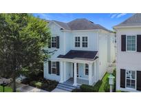 Charming two-story home with light blue siding, dark shutters, and a welcoming front porch with classic white columns at 1513 Resolute St, Celebration, FL 34747