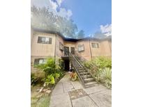 Brick building with dark trim, black staircase, green bushes, and sidewalk leading up to it at 1720 Foxhall Cir # 1720, Kissimmee, FL 34741