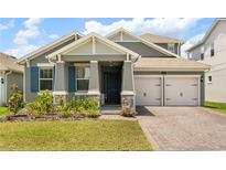 Charming two-story home featuring a two-car garage, landscaped yard, and a covered entryway at 19267 Allium Pl, Orlando, FL 32827